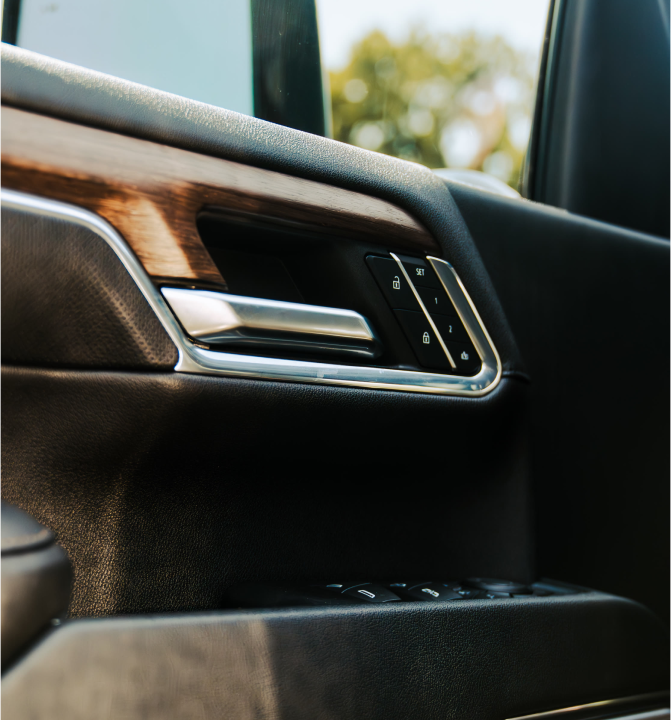 Close-up of a car interior door handle with lock and window controls.