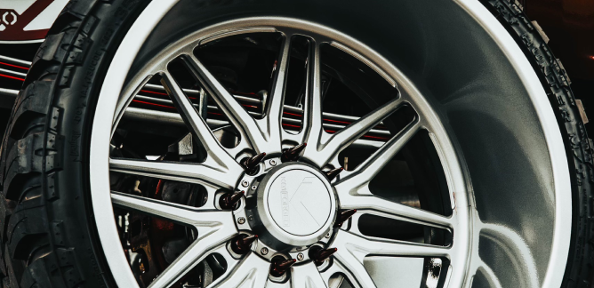 Close-up of a silver alloy car wheel with intricate spokes.