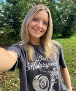 Person taking a selfie outside, wearing a gray 'B7 Motorsports' shirt.