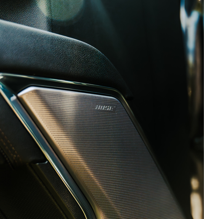 Close-up of a Bose speaker built into a car interior.