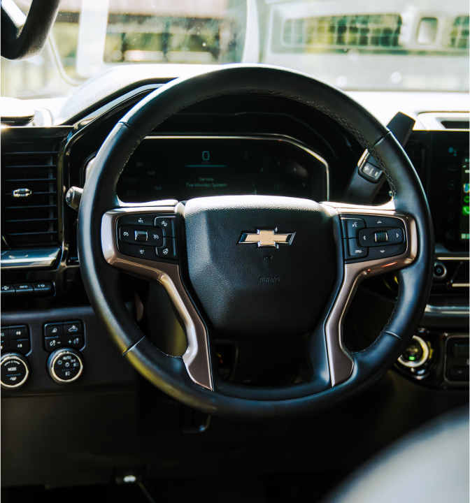 Close-up of a Chevrolet steering wheel and dashboard controls.